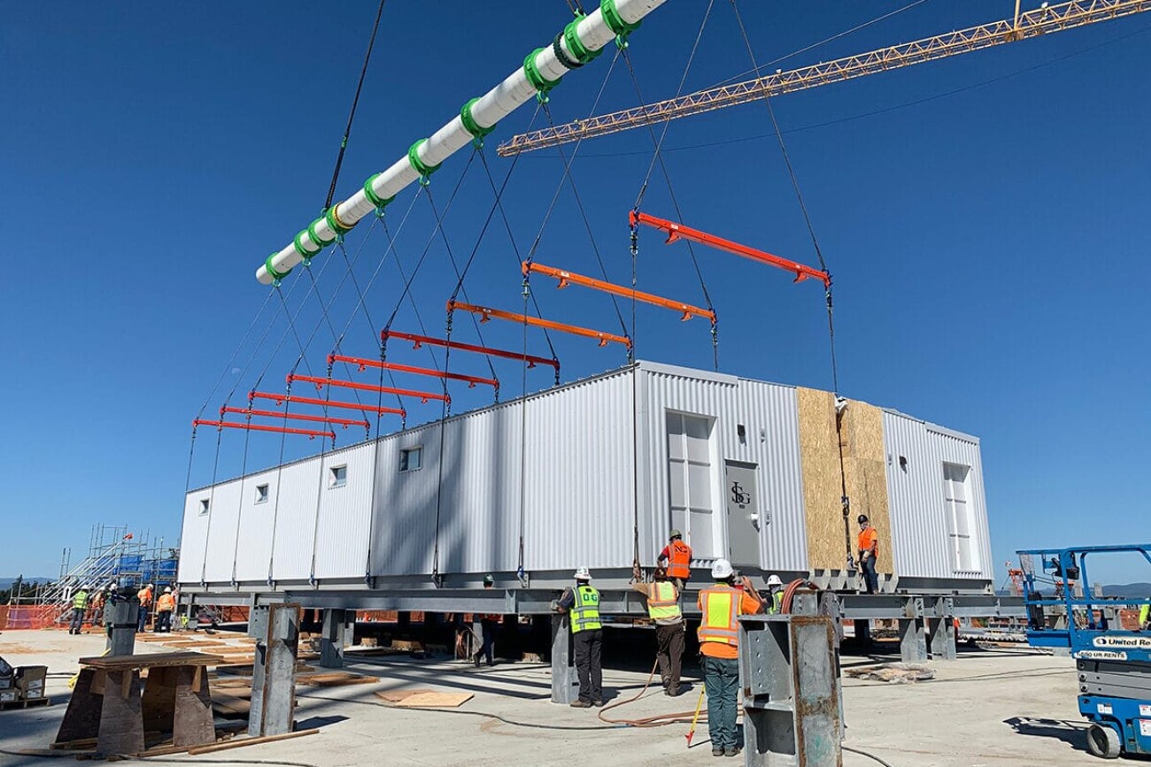 PCC sections being placed and married together on roof of large semiconductor factory.