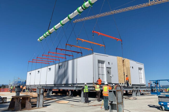PCC sections being placed and married together on roof of large semiconductor factory.
