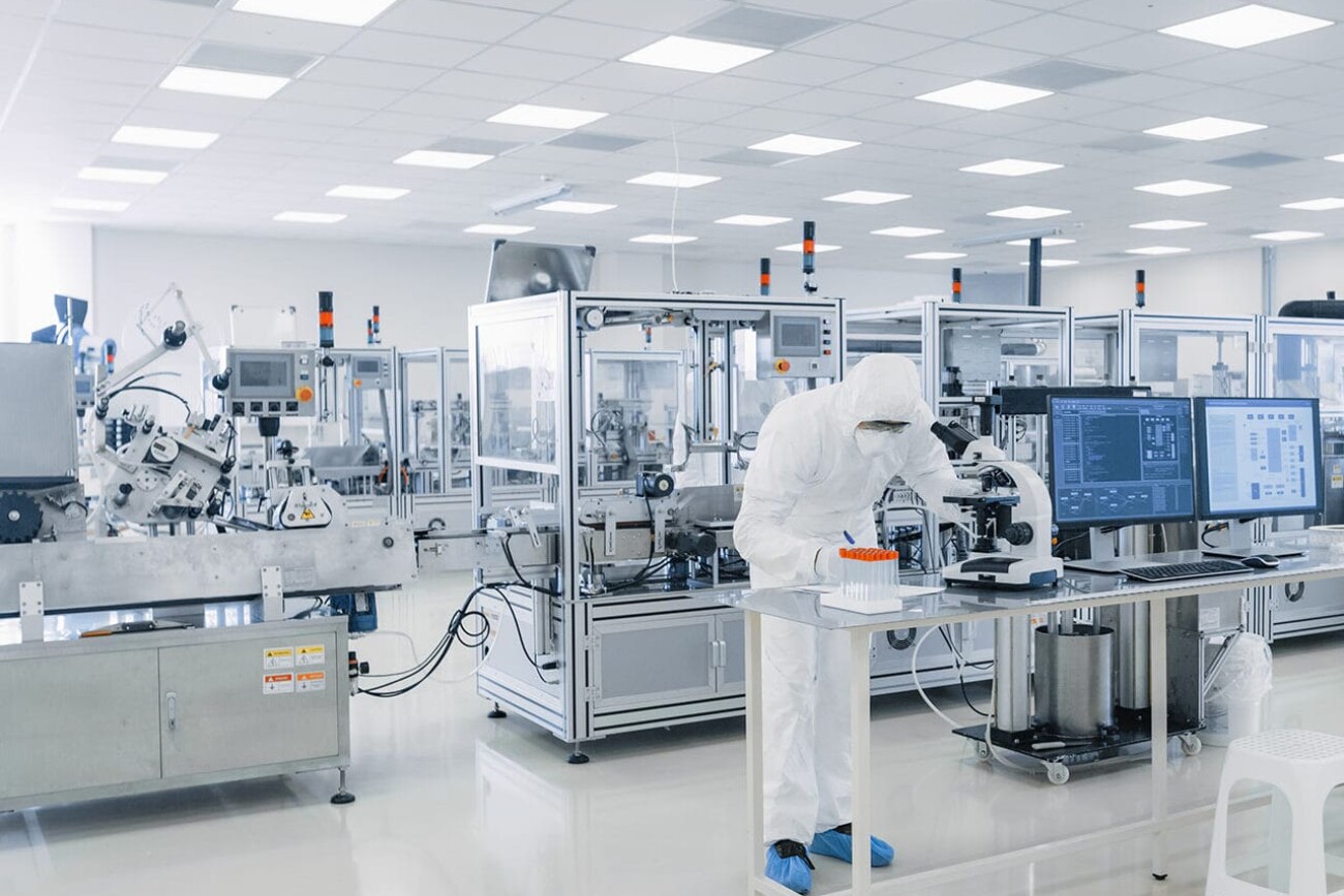 Shot of Sterile Pharmaceutical Manufacturing Laboratory where Scientists in Protective Coverall's Do Research, Quality Control and Work on the Discovery of new Medicine.