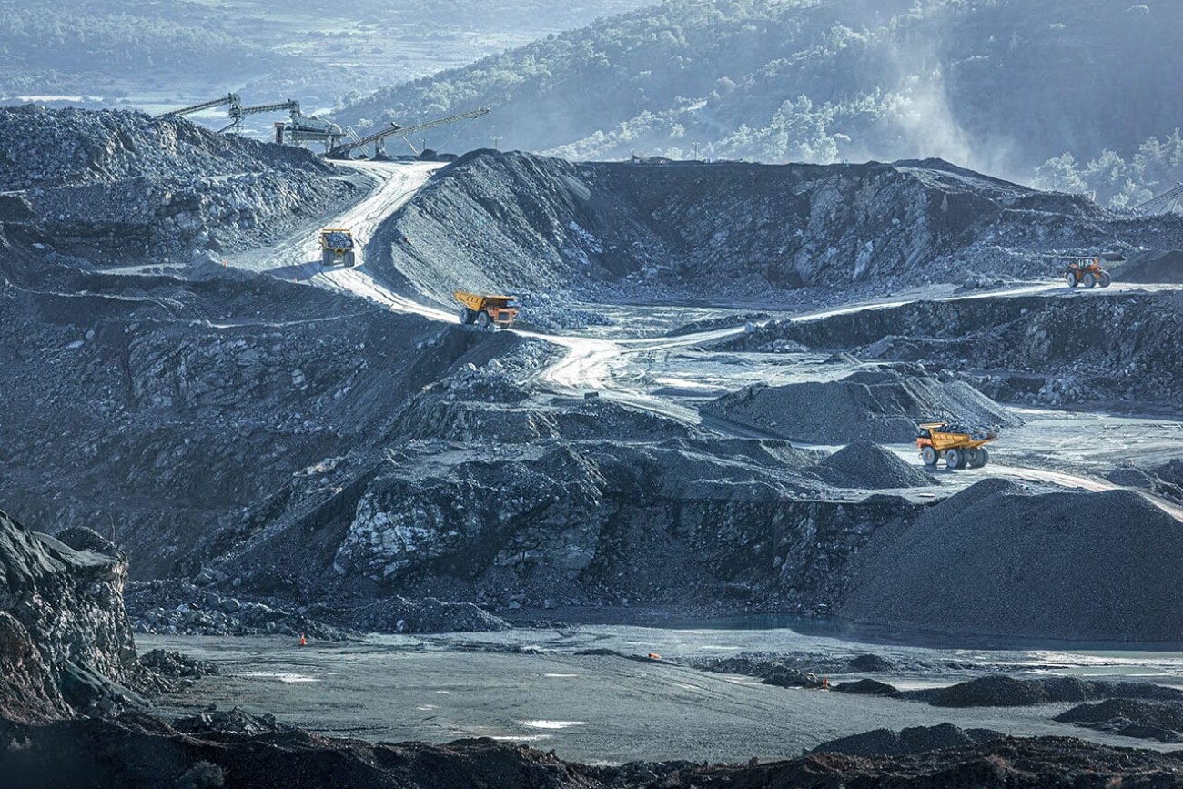 Mining trucks working at stone quarry, industrial landscape