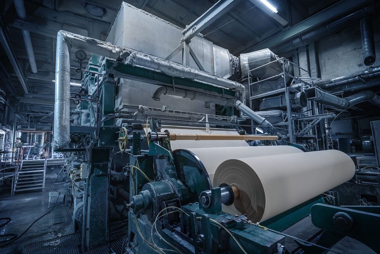 Paper production machine in wastepaper recycling factory. Paper and pulp mill.