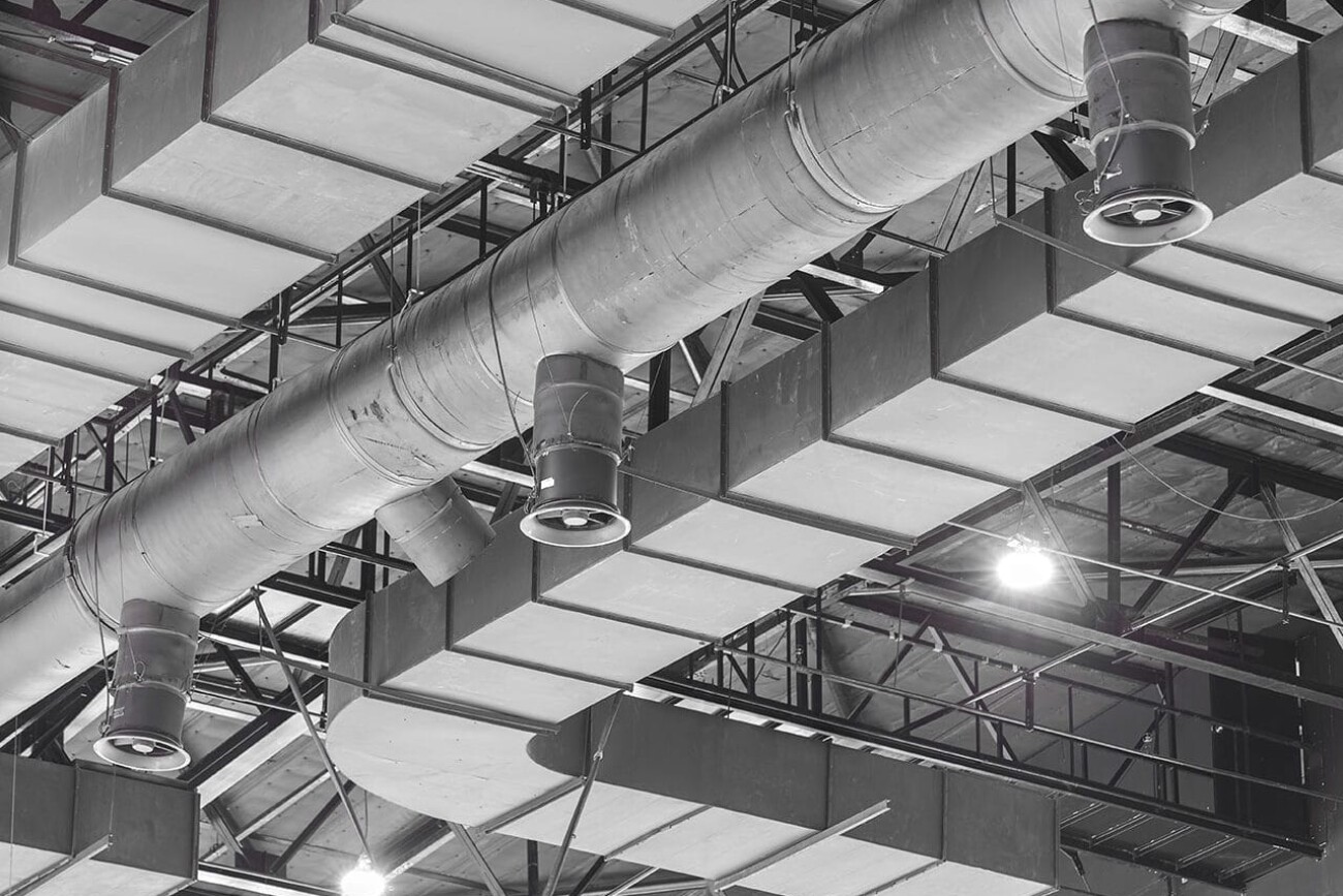 HVAC Duct Cleaning, Ventilation pipes in silver insulation material hanging from the ceiling inside new building.
